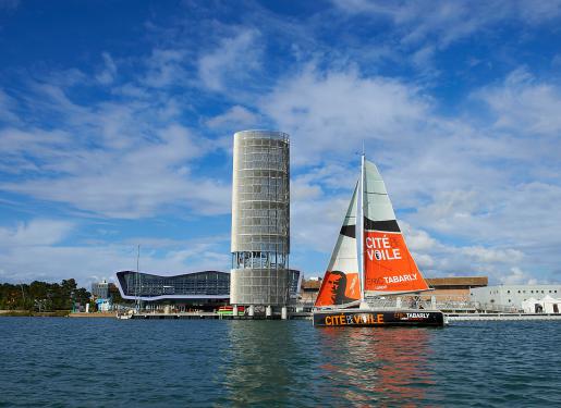 un bateau à voiles devant la cité de la voile de lorient