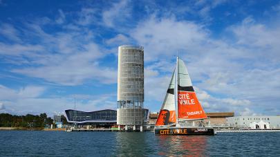 un bateau à voiles devant la cité de la voile de lorient